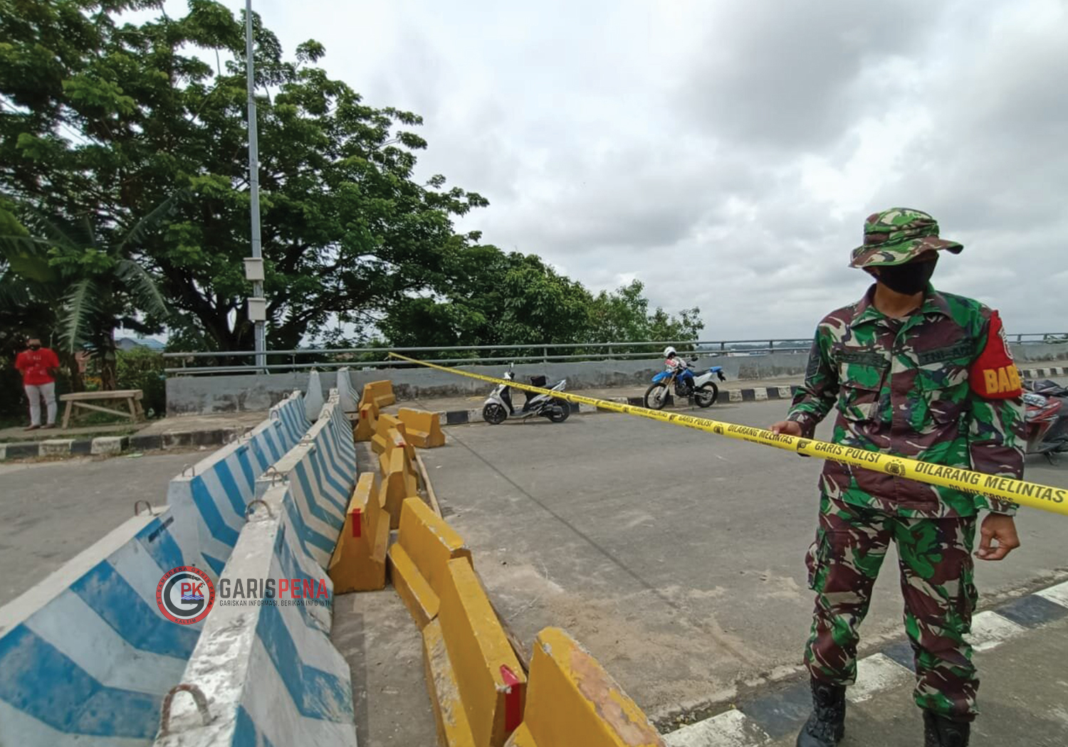 Petugas TNI memantau pemasangan barrier beton dan garis polisi di Jembatan Mahkota II.