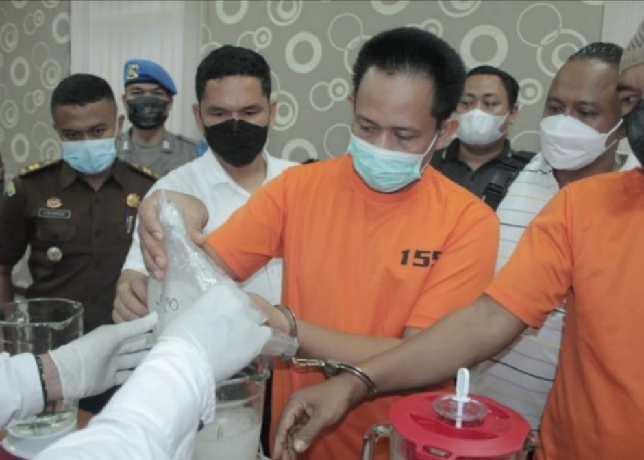 PEMUSNAHAN : Dua tersangka Ra dan Br saat memasukan barang haram ke blender untuk dimusnahkan.