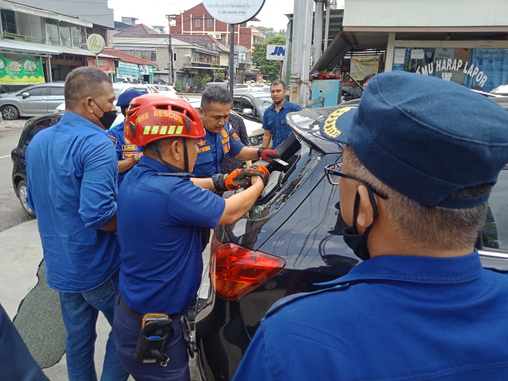 Foto: Anggota Pemadaman kebakaran saat melakukan evakuasi bayi terkunci di dalam mobil (Dok Disdamkar Samarinda)
