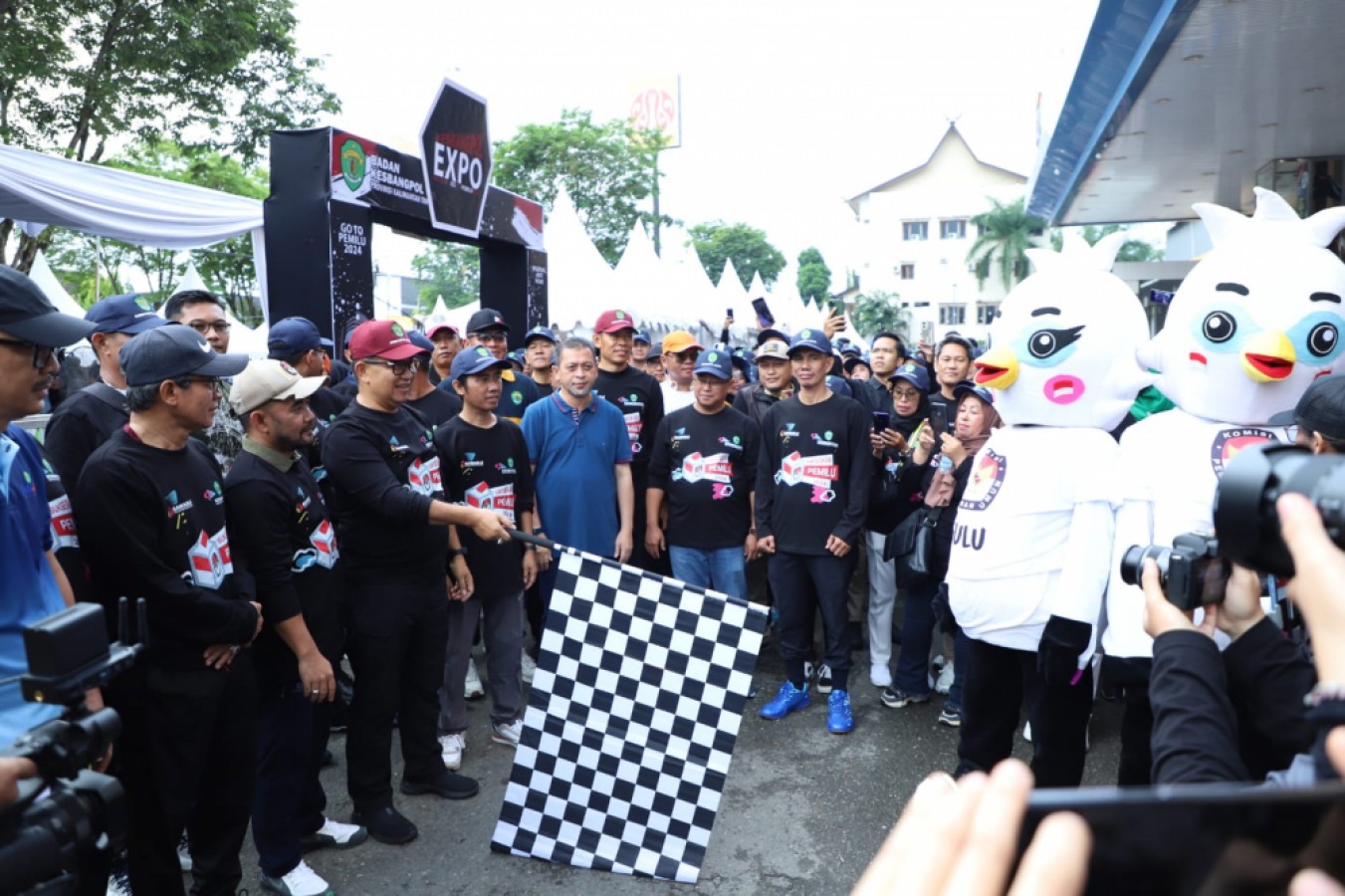 JASMANI DAN PEMILU SEHAT: Pj Gubernur Kaltim Akmal Malik mengibarkan bendera start sebagai tanda dimulainya jalan sehat rangkaian deklarasi pemilu sehat.